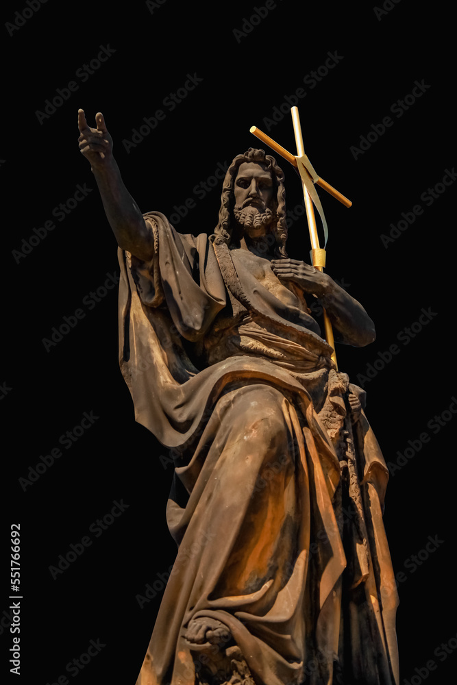 Ancient statues saint John, the Baptist against black background.