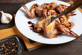 Chicken wing in teriyaki sauce is impaled on a fork. A dish of Asian cuisine.
