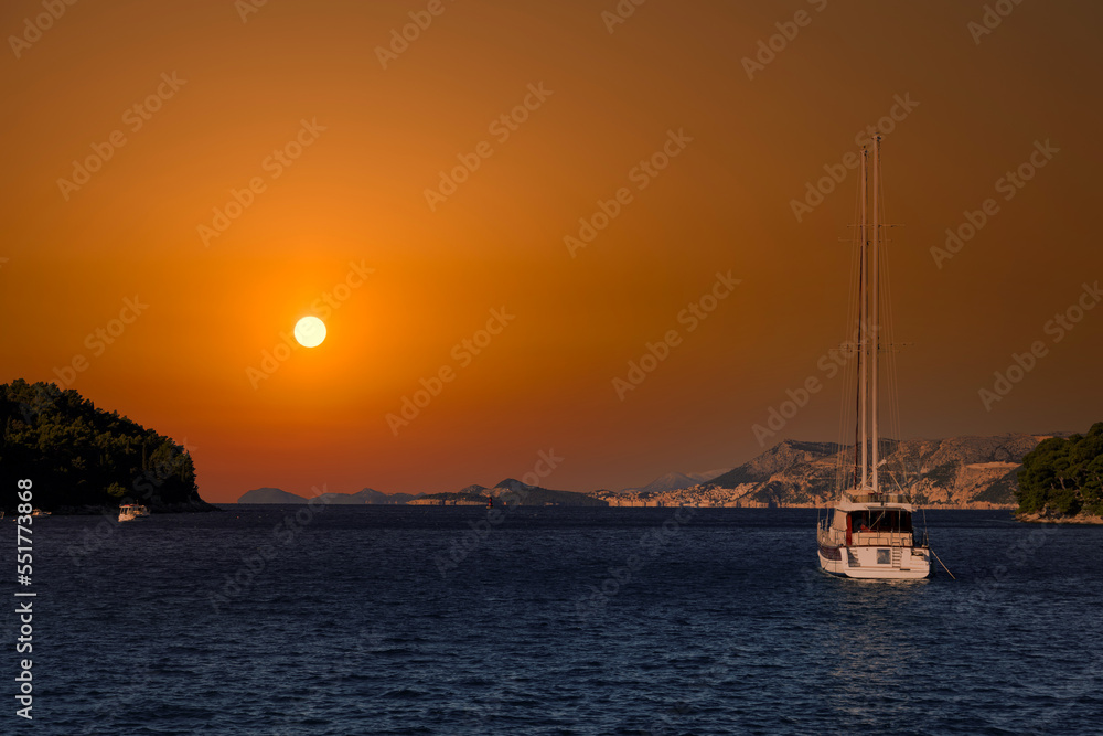 Sailing boat in the Mediterranean sea during scenic sunset.