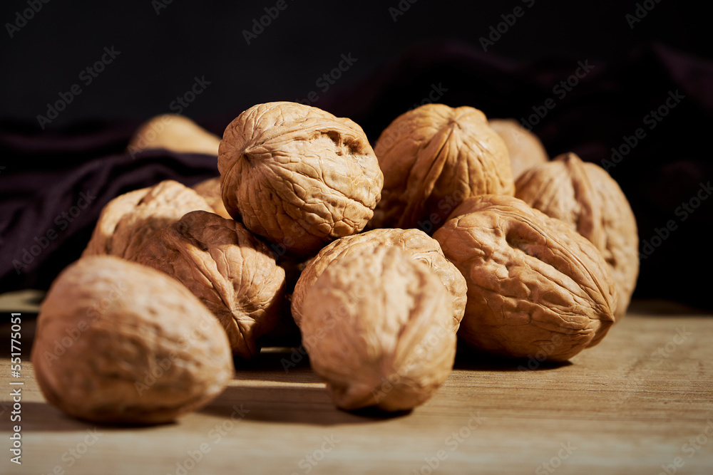 Close-up of tasty in-shell walnuts on wooden table Close-up of tasty in-shell walnuts on wooden table