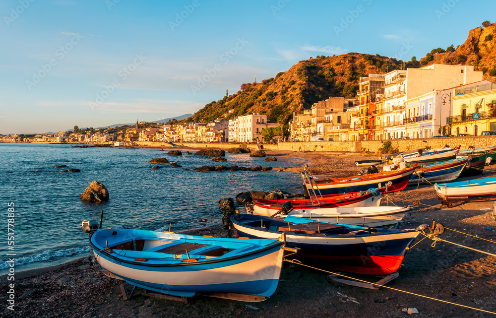 boats in a dock in  morning sunrise sea gulf with a embankment of a town on a background