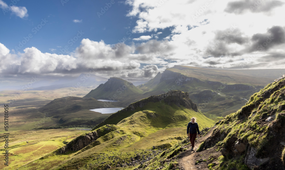 Woman hiking on Quiraing.It is a geological formation on the Scottish Isle of Skye and a hiker's paradise