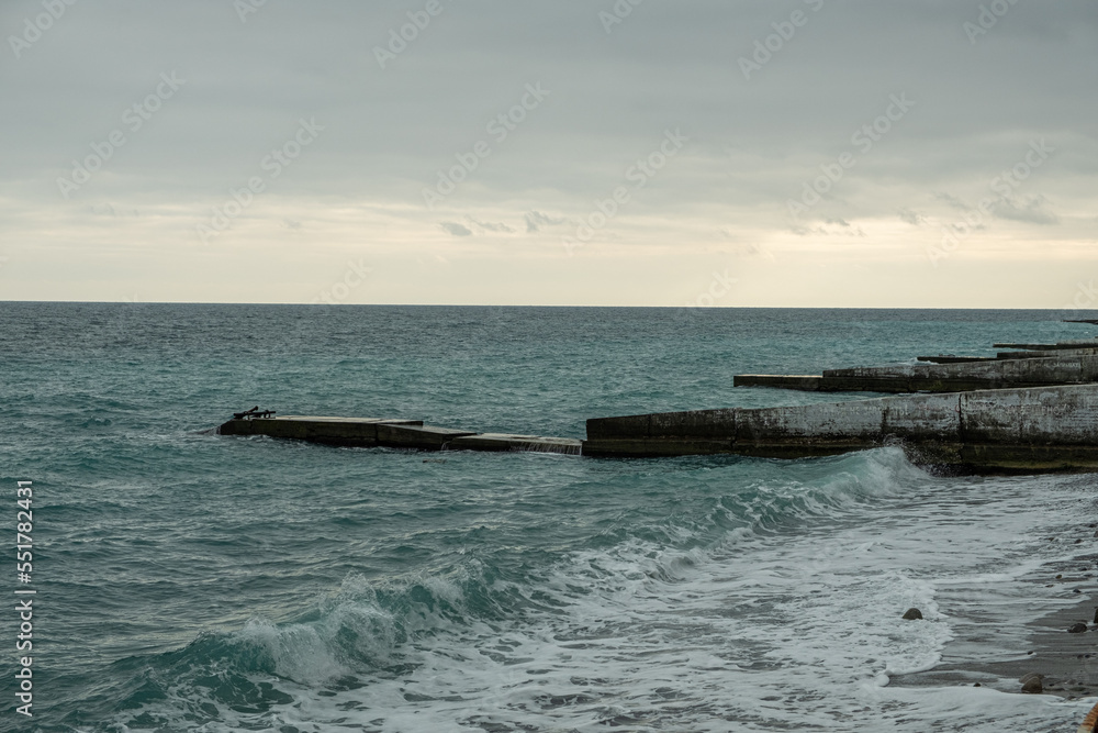 Protective structures on the coastline of the sea. Breakwaters protect the beach from erosion. Day, Spring. Russia.