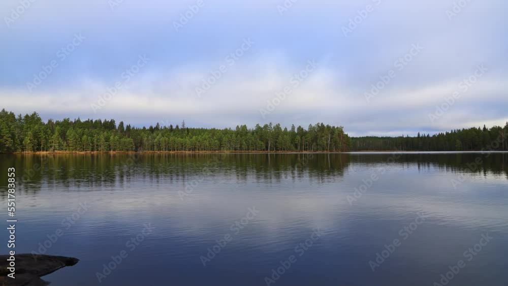 time lapse shot over a large lake with a forest on the opposite shore time lapse shot over a large lake with a forest on the opposite shore