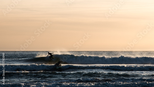 Surfer surfing the wave at dusk in Cadiz © Ibon