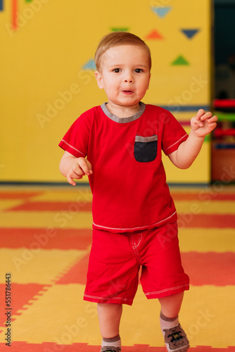 Happy laughing boy 1-2 years old having fun in ball pit  in kids amusement park and indoor play center. Activity toys for little kid