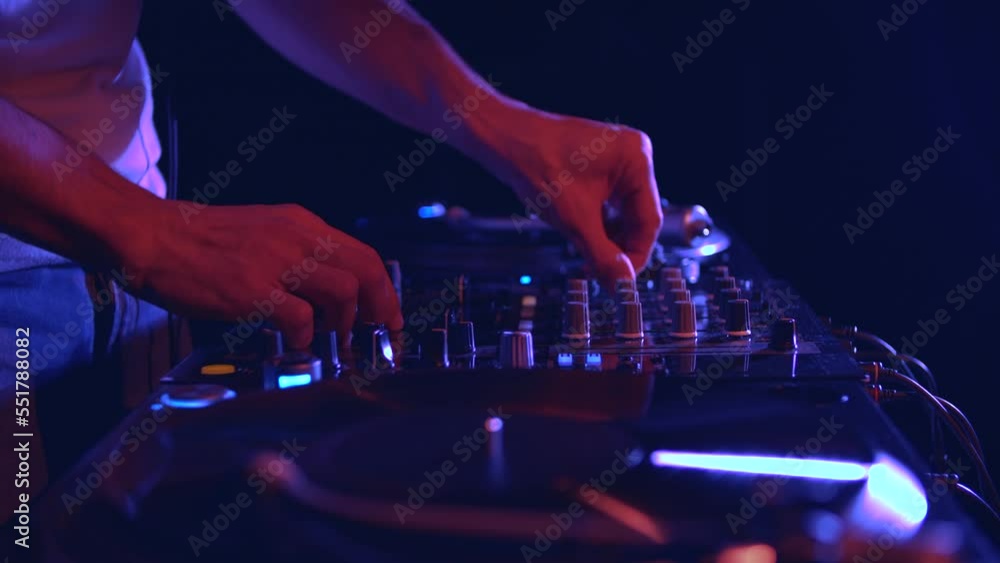 Club DJ mixing musical tracks with sound mixer. Disc jockey plays music with vinyl records Club DJ mixing musical tracks with sound mixer. Disc jockey plays music with vinyl records