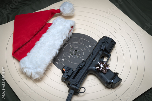 Christmas shooting.  A pistol with a collimator sight and butt, a gnome's hat and a target for shooting. photo