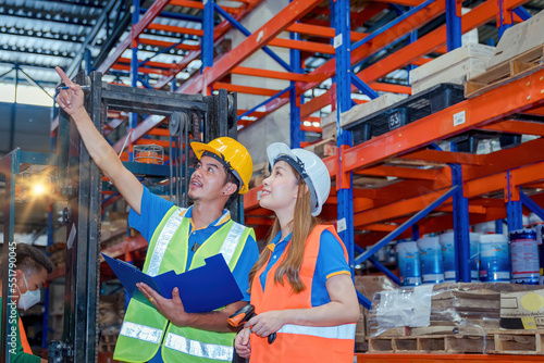 Portrait asian engineer in helmets order on tablet for checking goods and supplies on shelves with goods background in warehouse.logistic business export ,Warehouse worker checking packages on store.