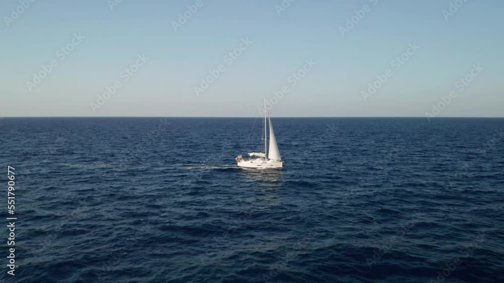 Aerial view of a luxury sailboat passing by in the middle of the Mediterranean Sea near island Gozo, Malta. Aerial view of a luxury sailboat passing by in the middle of the Mediterranean Sea near island Gozo, Malta.