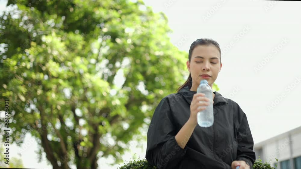 Portrait happy slim woman drinking water after workout exercising in the city at sunrise. Young beautiful female drinking water after jogging running outdoor. Healthy and active lifestyle concept. Portrait happy slim woman drinking water after workout exercising in the city at sunrise. Young beautiful female drinking water after jogging running outdoor. Healthy and active lifestyle concept.