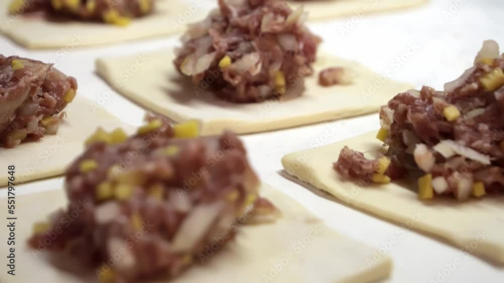 Minced meat in dough, cooking baked meat in dough prepared with hands close-up Minced meat in dough, cooking baked meat in dough prepared with hands close-up