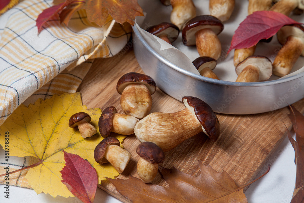 Several Imleria Badia or Boletus badius mushrooms commonly known as the bay bolete, vintage baking sheet with mushrooms on wooden cutting board.. Several Imleria Badia or Boletus badius mushrooms commonly known as the bay bolete, vintage baking sheet with mushrooms on wooden cutting board..