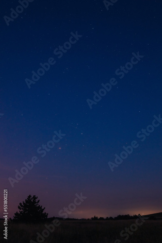 Milky Way stars with countryside landscape.