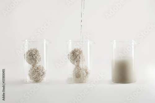 Pouring water into the glasses with cat litter to show it’s organic nature and ability to decompose.