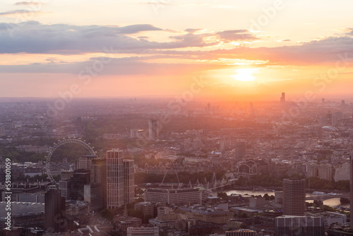 Panoramic view of London city skyline illuminated by colorful sunset light  aerial shot. Famous landmark buildings and architectural attractions on the river banks.