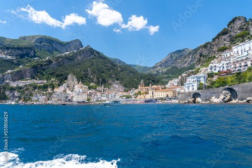 View of the Amalfi coast, captured from a boat on a sunny day.