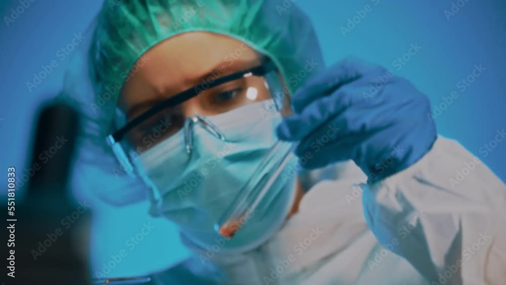 Woman in goggles and mask working with test tubes in laboratory. Woman in goggles and mask working with test tubes in laboratory.