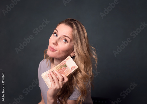 pretty young woman holding a lot of 5 thousandth bills in her hands. photo