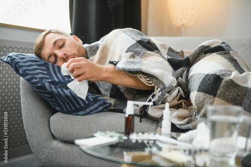 Принти на полотні Sick bearded man who has bad cold or seasonal flu sitting on couch at home