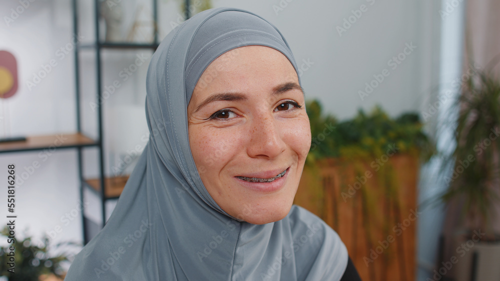 Portrait of happy calm young muslim business woman wearing hijab headscarf smiling friendly, glad expression, dreaming resting, relaxation feel satisfied concept good news. Girl at modern home office Portrait of happy calm young muslim business woman wearing hijab headscarf smiling friendly, glad expression, dreaming resting, relaxation feel satisfied concept good news. Girl at modern home office