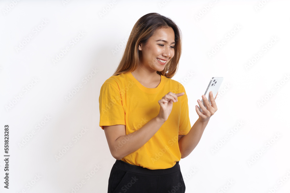 Hot asian pretty young woman smiling isolated on white, yellow t-shirt, using cellphone Hot asian pretty young woman smiling isolated on white, yellow t-shirt, using cellphone