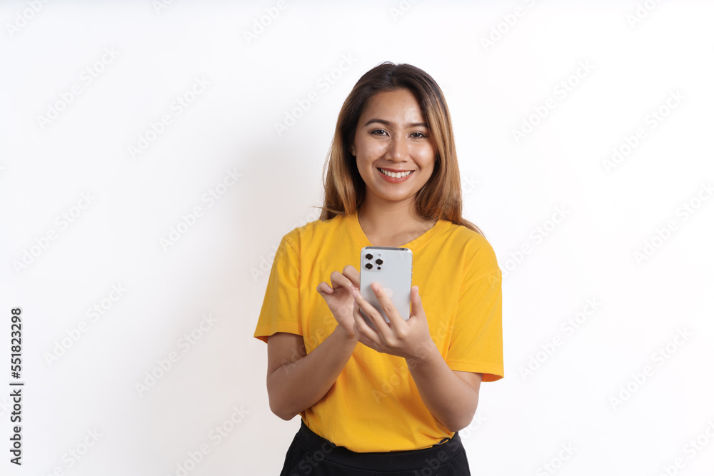 Hot asian pretty young woman smiling isolated on white, yellow t-shirt, using cellphone Hot asian pretty young woman smiling isolated on white, yellow t-shirt, using cellphone