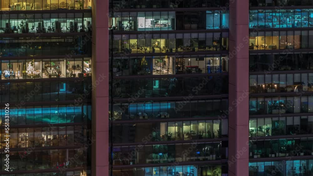 Big glowing windows in modern office buildings timelapse at night, in rows of windows light shines. People working inside and workers make a renovation Big glowing windows in modern office buildings timelapse at night, in rows of windows light shines. People working inside and workers make a renovation