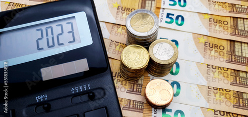 Energy and financial crisis in Europe in 2023. The ever-increasing cost of energy, food and goods. Calculator and a lot of euro coins on the background of banknotes of 50 euros