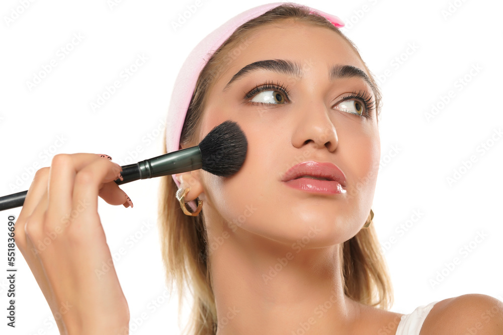 Woman using make-up brush, isolated on white background Woman using make-up brush, isolated on white background