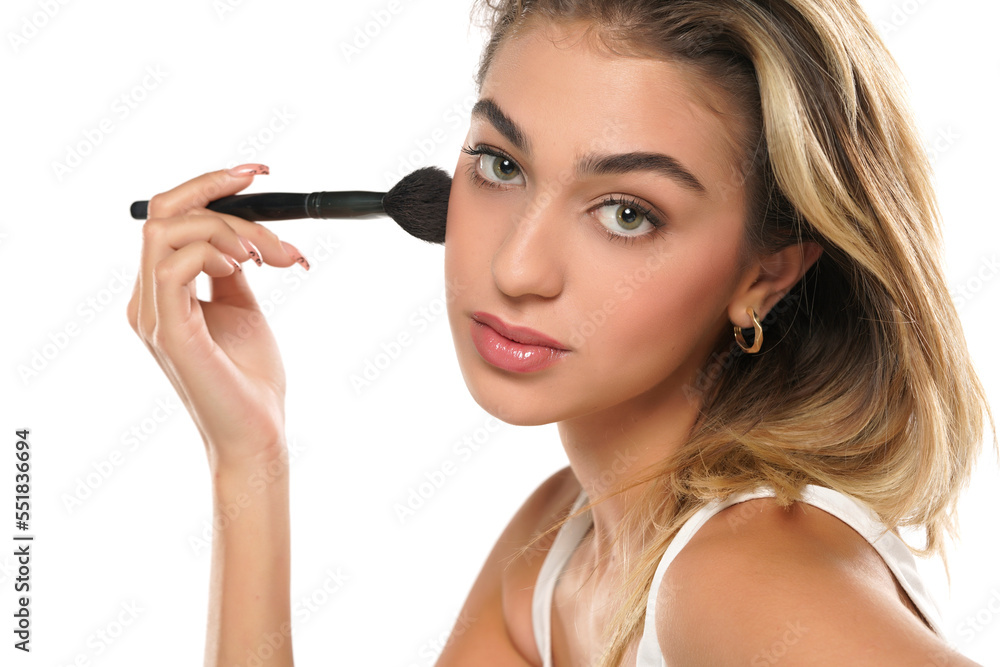 Woman using make-up brush, isolated on white background Woman using make-up brush, isolated on white background