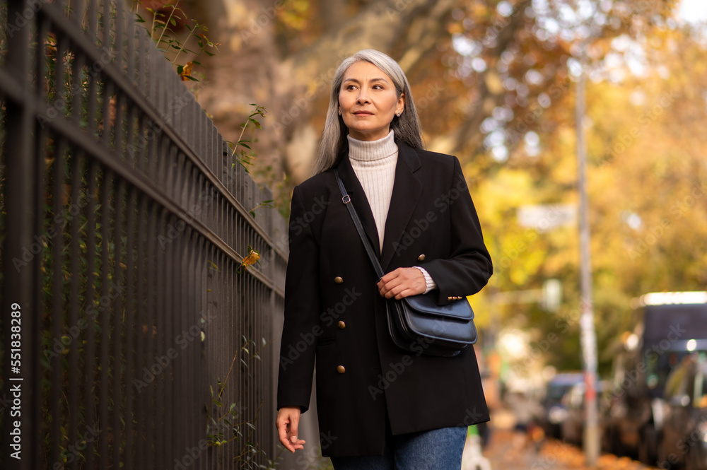 Pretty mature woman walking in the autumn park Pretty mature woman walking in the autumn park