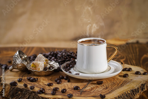 Hot Turkish coffee on wooden floor, Turkish delight next to it. 