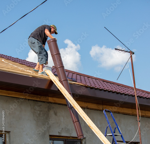 Wallpaper Mural Workers install metal roofing on the wooden roof of a house. Torontodigital.ca