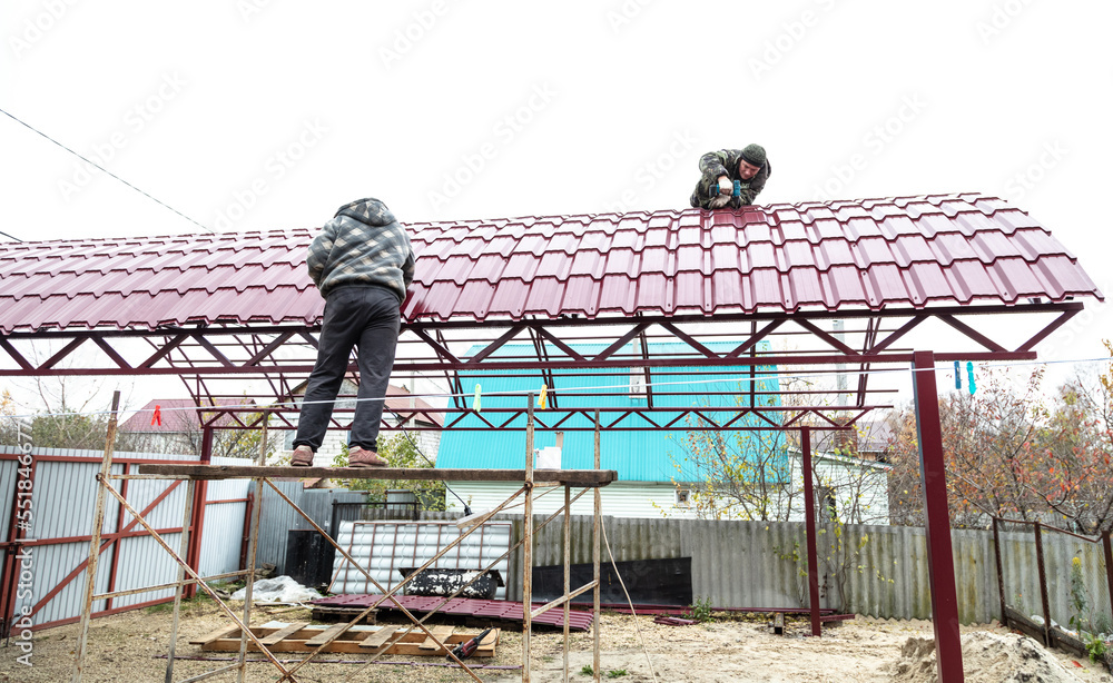 Naklejka premium Workers cover the canopy with metal sheets.