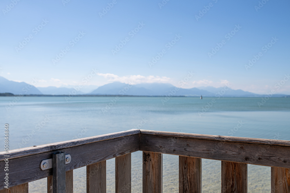 sailboat and railing of viewpoint on lake chiemsee