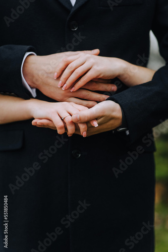Hands, fingers of the bride and groom, man and woman together close-up.