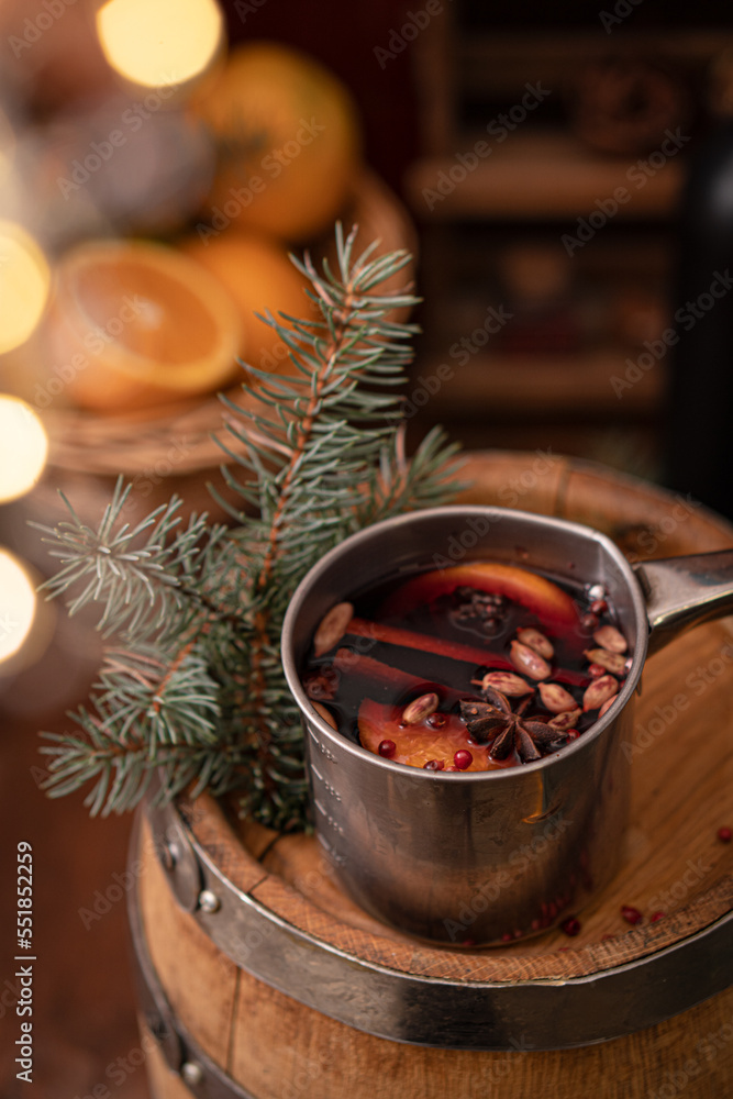 Mulled wine in a copper pot with spices on a wooden table