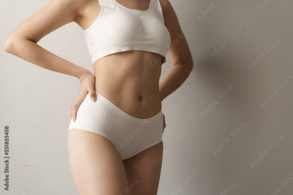 Pretty asian woman wears white lingerie poses against grey background with body  care, bra, underwear concept. Stock Photo