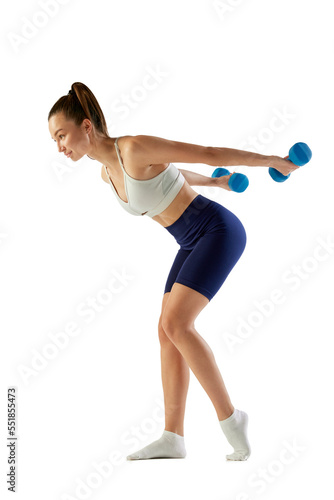 Portrait of young sportive woman training, doing exercises with dumbbells isolated over white background. Concept of sport, fitness, health © master1305