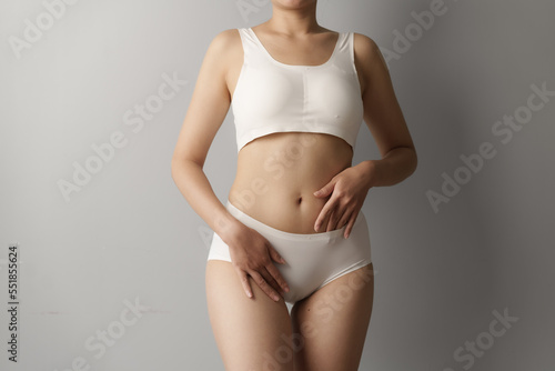 Close up asian woman cropped shot with white panties on grey background, vagina healthy concept. © makibestphoto