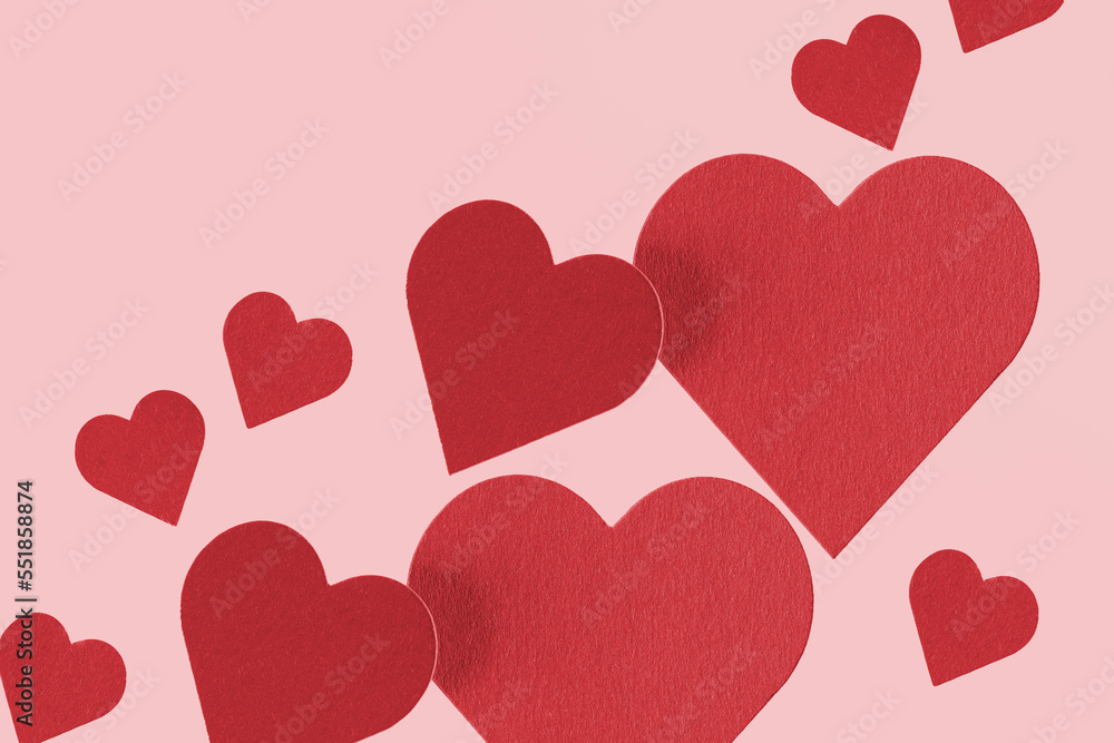 Floating red paper hearts on a pink background
