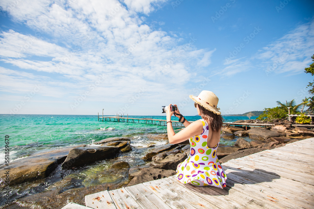 Young Asian lady tourist on the wooden bridge and take a photo on her holiday. Trat Province, Thaiand. Young Asian lady tourist on the wooden bridge and take a photo on her holiday. Trat Province, Thaiand.