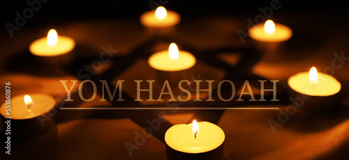 Burning candle on flag of Israel background, space for text. Yom HaShoah (in English as Holocaust Remembrance Day, or Holocaust Day) photo