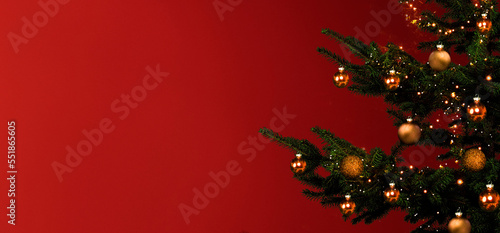 Weihnachtsbaum mit Goldenen Kugeln vor rotem Hintergrund