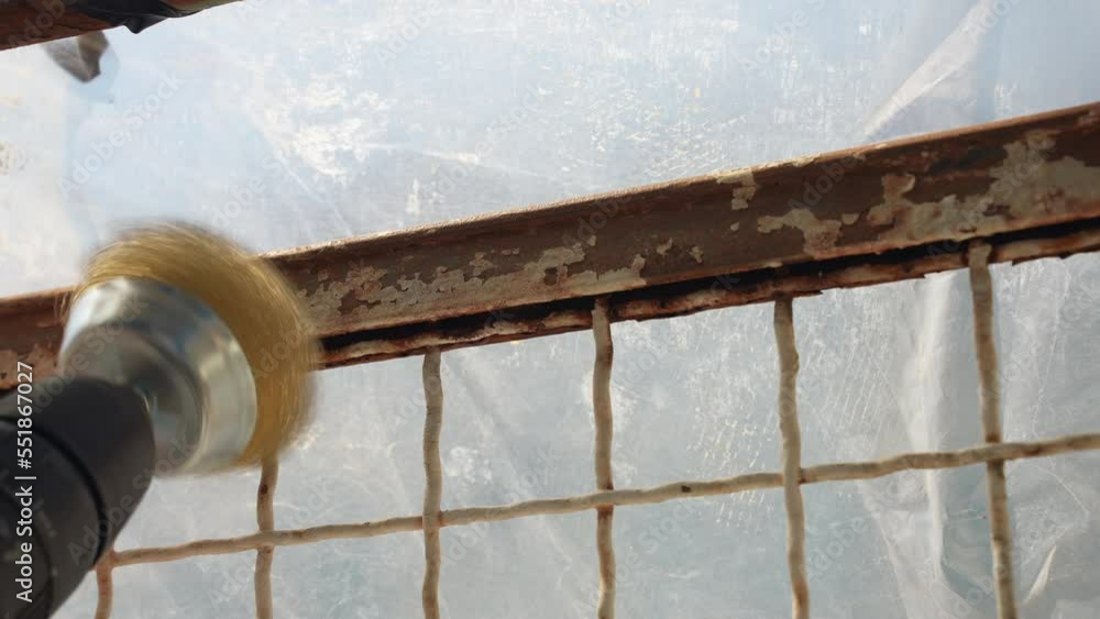 Electric grinder with metal brush nozzle rotating at an angle and