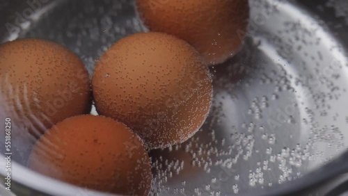 Close up boiled egg in the pot. Breakfast cooking.
