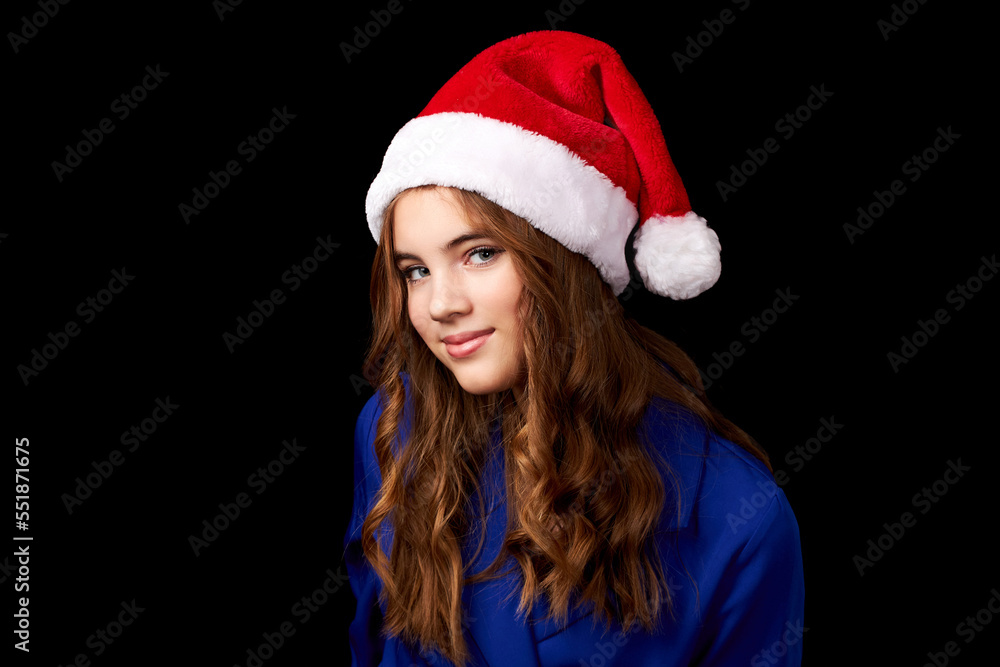 caucasian girl with long hair in blue dress wearing santa claus hat isolated on black background caucasian girl with long hair in blue dress wearing santa claus hat isolated on black background