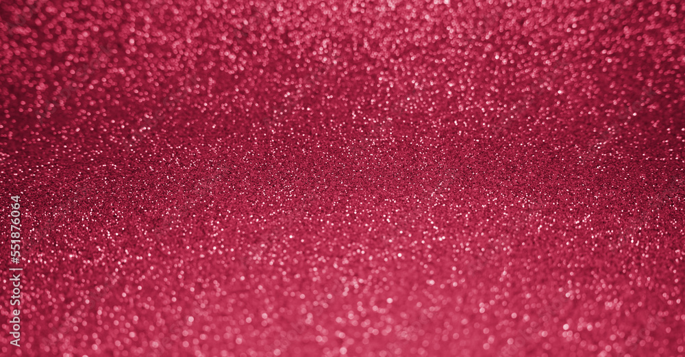 Glitter background colored in trendy color 2023 Viva Magenta in blur. Abstract shiny background. Banner. Selective focus.
