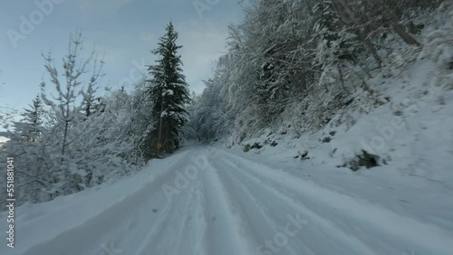Car trace on a mountain road in the shade covered with fresh snow
